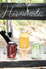 Outdoor Wedding Drink Bar with Big Bottles of Lemonade, Mojito, and Cherry Drink - 706331351