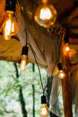 Hanging bulbs with warm light on an outdoor terrace. Vertical photo orientation
