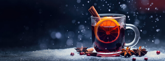 Close up photography of mulled vine in glass with cinnamon spices, orange and christmas background