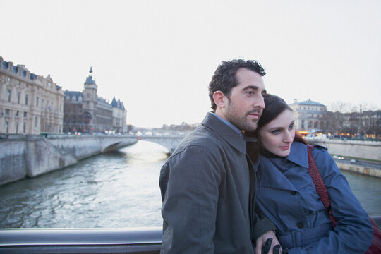 Young couple hugging on a bridge over the Seine river, Paris, France
