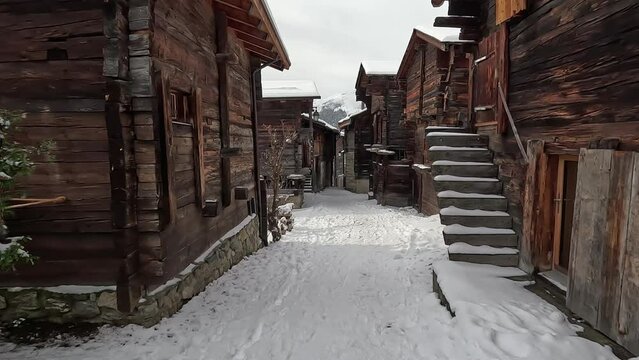 Bellwald in Switzerland. Snow-covered path leads through the middle of an old traditional Swiss village