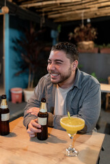 Young Hawaiian Man Smiling and Enjoying a Beer at Restaurant