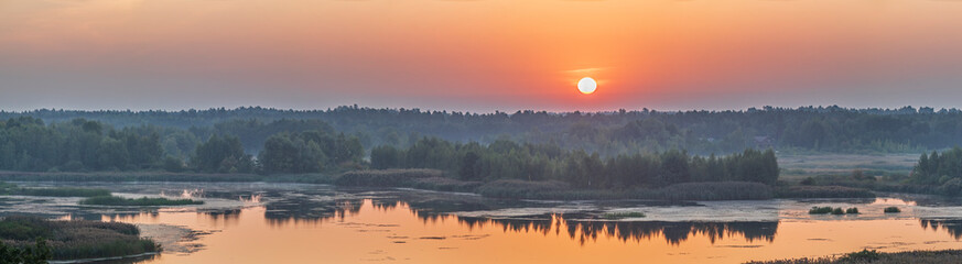Sunrise on the river highlights the light morning fog on the Dnieper River, Ukraine.