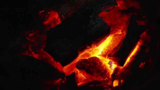 A bonfire. Close up burning log of firewood in fireplace. Wooden logs are burning. Embers in a fireplace. Burning wood of bonfire