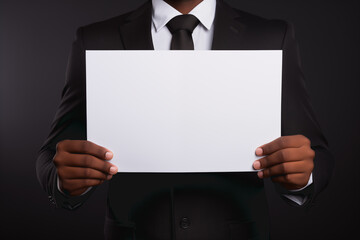 An African-American man dressed in a suit holds a blank sheet of paper with space to put texts