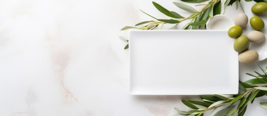 Wedding table with decorated plates and olive branches, modern template with blank paper card. Copy space.