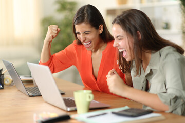 Two excited tele workers celebrating success online - Powered by Adobe