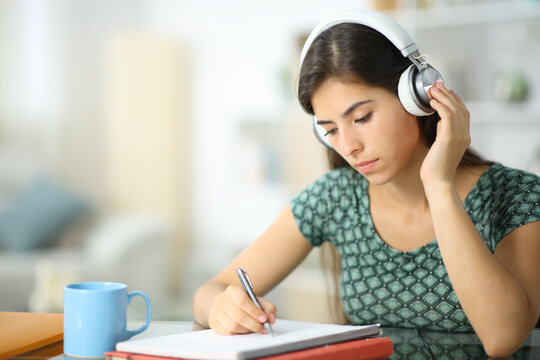 Student listening audio guide studying at home