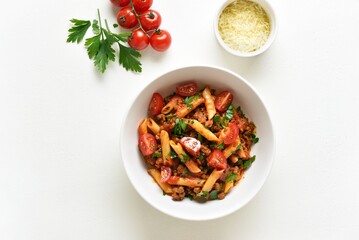 Bolognese penne pasta with minced meat, tomatoes and greens