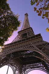 Vue en contre plongée sur la tour Eiffel fraichement repeinte, ciel bleu avec effet de couleurs nuancées 