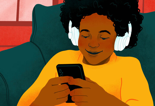 Smiling girl with headphones and smart phone playing video game
