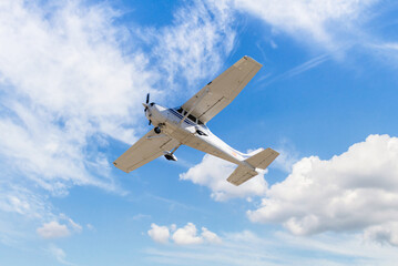 Single engine ultralight plane flying in the blue sky with white clouds - Powered by Adobe