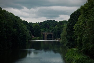 Fototapeta na wymiar Overcast Elegance: The River's Ancient Crossing