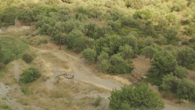 Arid mediterranean landscape with green shrub grass and winding dirt path