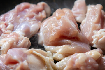 鶏肉(鶏モモ肉)をフライパンで焼く調理シーンのアップ。
