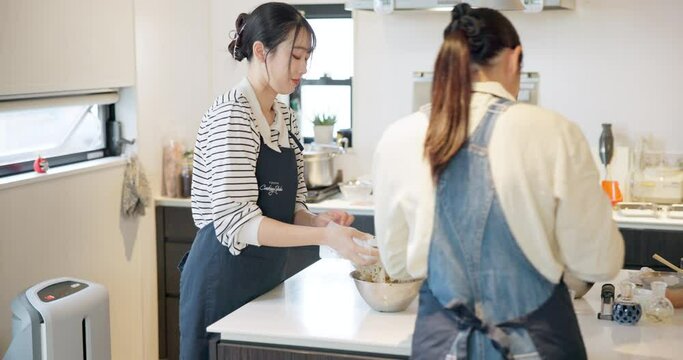 Cooking, women and mixing in kitchen, japanese and chef food in class, professional and skill. Restaurant, teaching and course for culinary skills, working together and aprons for cleanliness
