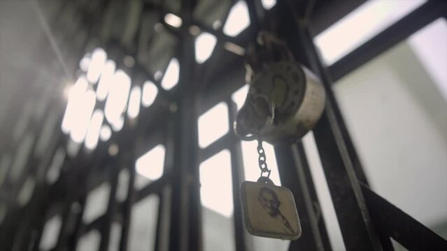 An office premise is locked with the keys hanging - security  protection  theft  breaking the lock. A lock and key hanging on an iron grill gater - safety  an old building
