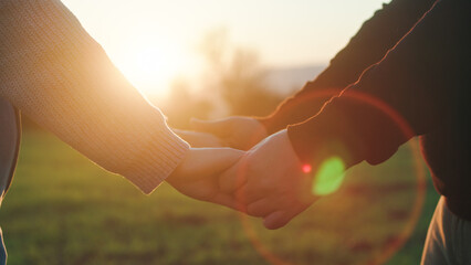 Couple hands at sunset light