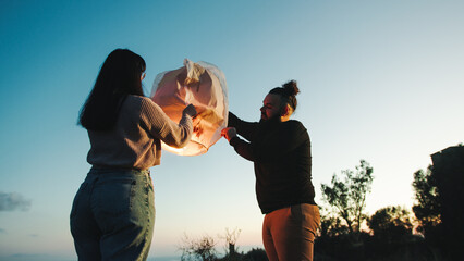 Engaged couple prepares flying lantern for valentines day