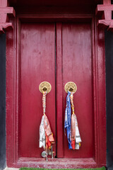 A beautiful red wooden door with brass knockers - culture concept.CR2