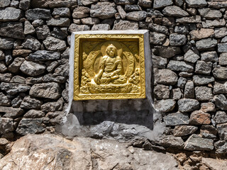 A Golden Buddha figure fixed on a monastery wall - Spirituality concept.
