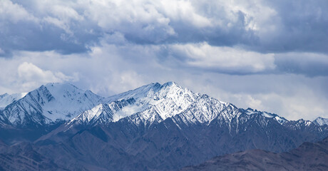 Snow-covered barren mountains during the daytime.