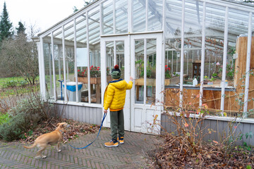 Boy with his dog in a greenhouse in winter