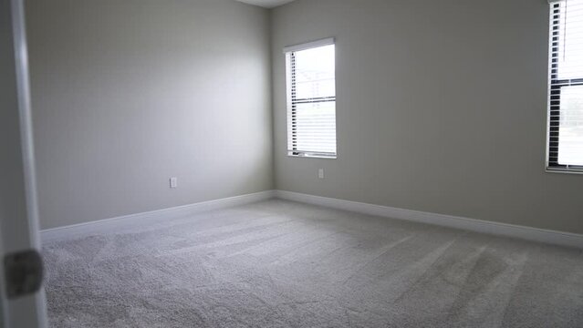 Entering an empty room with light walls and sunlight shining through the window