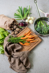 Organic carrots, potatoes  layout. Vegetables fresh from the garden with concrete background.