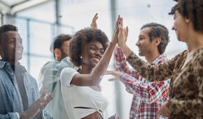 Successful business people giving each other a high five in a meeting