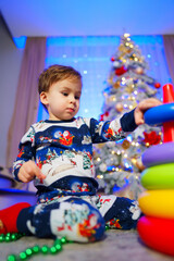 Capturing the pure delight of a young childs play as he becomes enchanted by a toy while surrounded by the enchanting beauty of a Christmas tree.