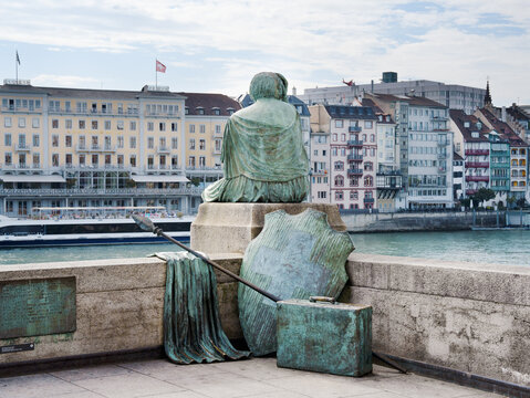 &ldquo;Helvetia auf Reisen&rdquo; statue on the banks of the Rhine in Basel, photographed from behind on a moderately cloudy day.
