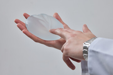 silicone breast implant in the hand of a plastic surgeon doctor, mastopexy concept, BREAST LIFT