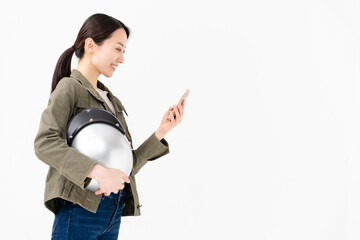 ヘルメットを抱えてスマートフォンを操作する女性