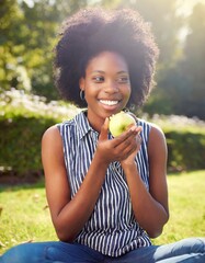 African American Female eating apple in the park