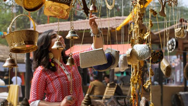 Beautiful Indian woman shopping for home decor from a local fair in India - unique handicraft items. Young women searching for beautiful decorative household items - delightful shopping spree  home...