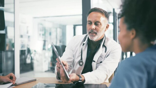 Man, doctor and tablet in discussion with nurses, interns or medical employees at hospital. Surgeon or healthcare professional talking to staff of practitioners with technology for meeting at clinic