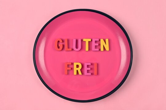 Pink plate with lettering " Glutenfrei " meaning Gluten free. Nutritional concept.