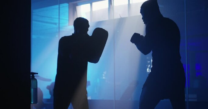 Men, boxing and workout in gym, training and silhouette for people, boxer and strong. Exercise, sports and arm muscles for power, self defense and coaching for challenge, mma and fighting skills