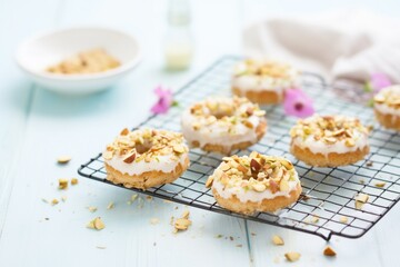 iced donuts with nuts on a cooling rack