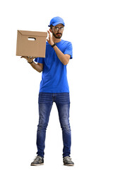 A male deliveryman, on a white background, in full height, shakes a box