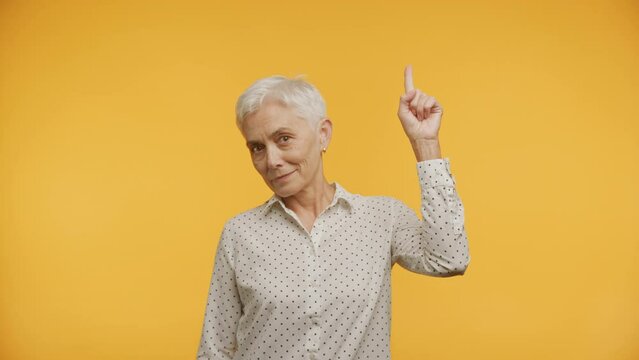 Senior Woman with Idea on Yellow