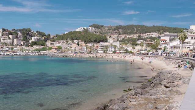 a zoom in shot of the beach and waterfront of the town of port de soller on mallorca, spain