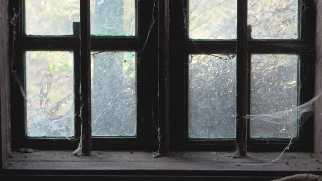Old abandoned rustic house window full of spider webs