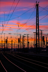 Colorful sunset at railway station in Dortmund, Germany. Red and blue sky above railroad tracks,...