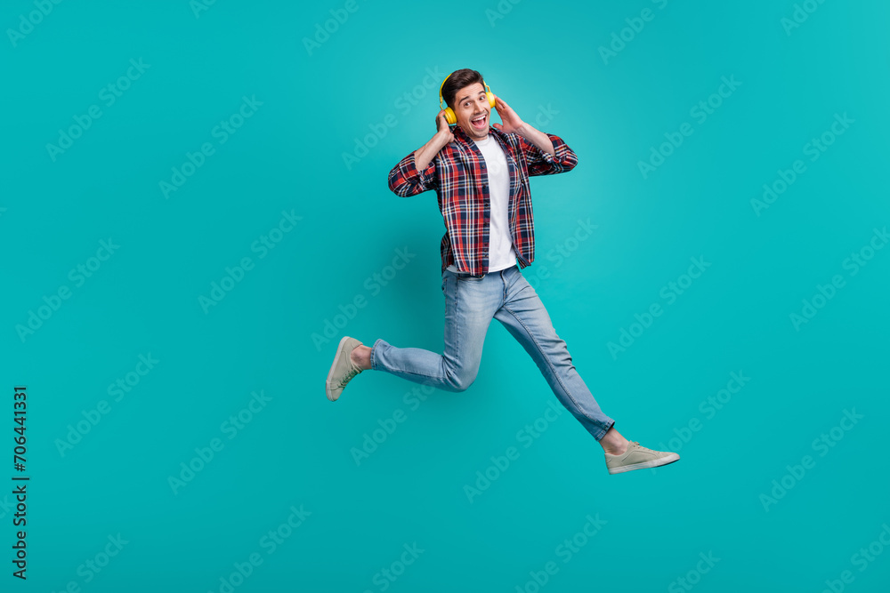 Canvas Prints Full length photo of cool funky man dressed plaid shirt jumping high enjoying music headphones isolated turquoise color background