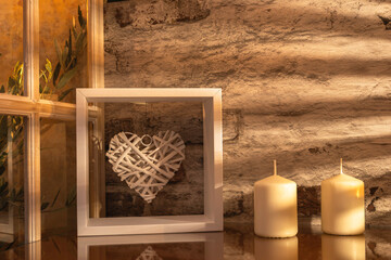 Panorama de fond d'un vieux mur en pierres avec un cœur et des bougies pour création d'arrière plan. Panoramique avec jeu d'ombre et de lumière à travers une fenêtre.	