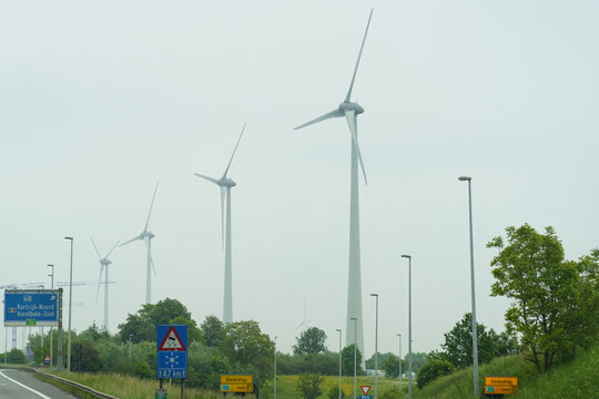 Wind generators stand along the road.