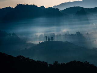 The rays of the morning sun through the fog in the mountains