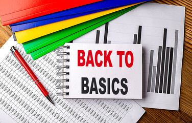BACK TO BASICS text on a notebook with pen, folder on a chart background